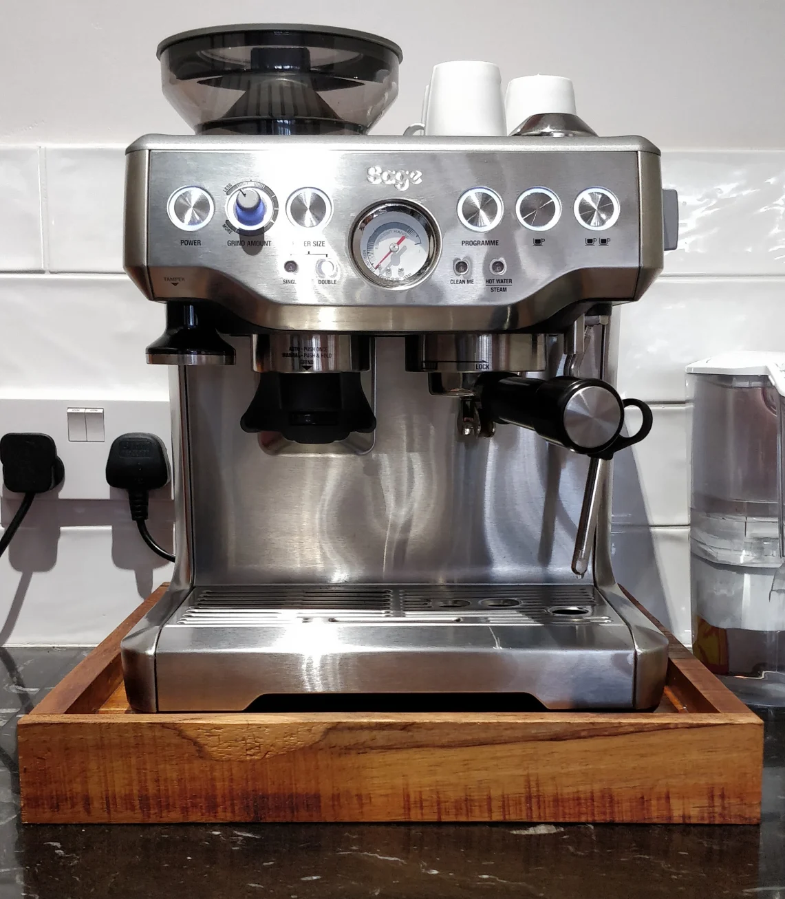 Photo of a silver coffee machine on a wooden tray